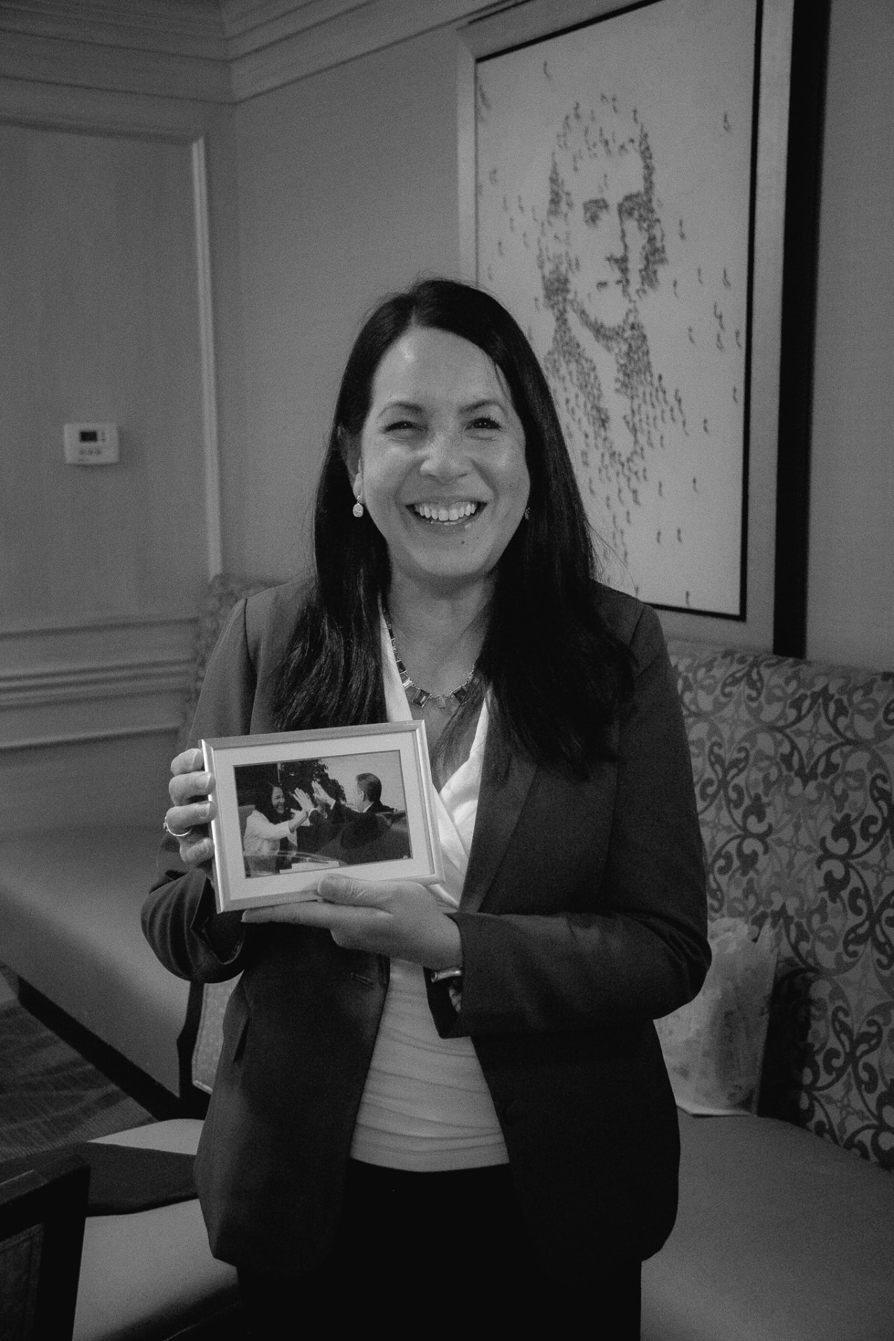 Dr. Marga Macias smiling and holding a framed photo at Media Mastery Experts LIVE!