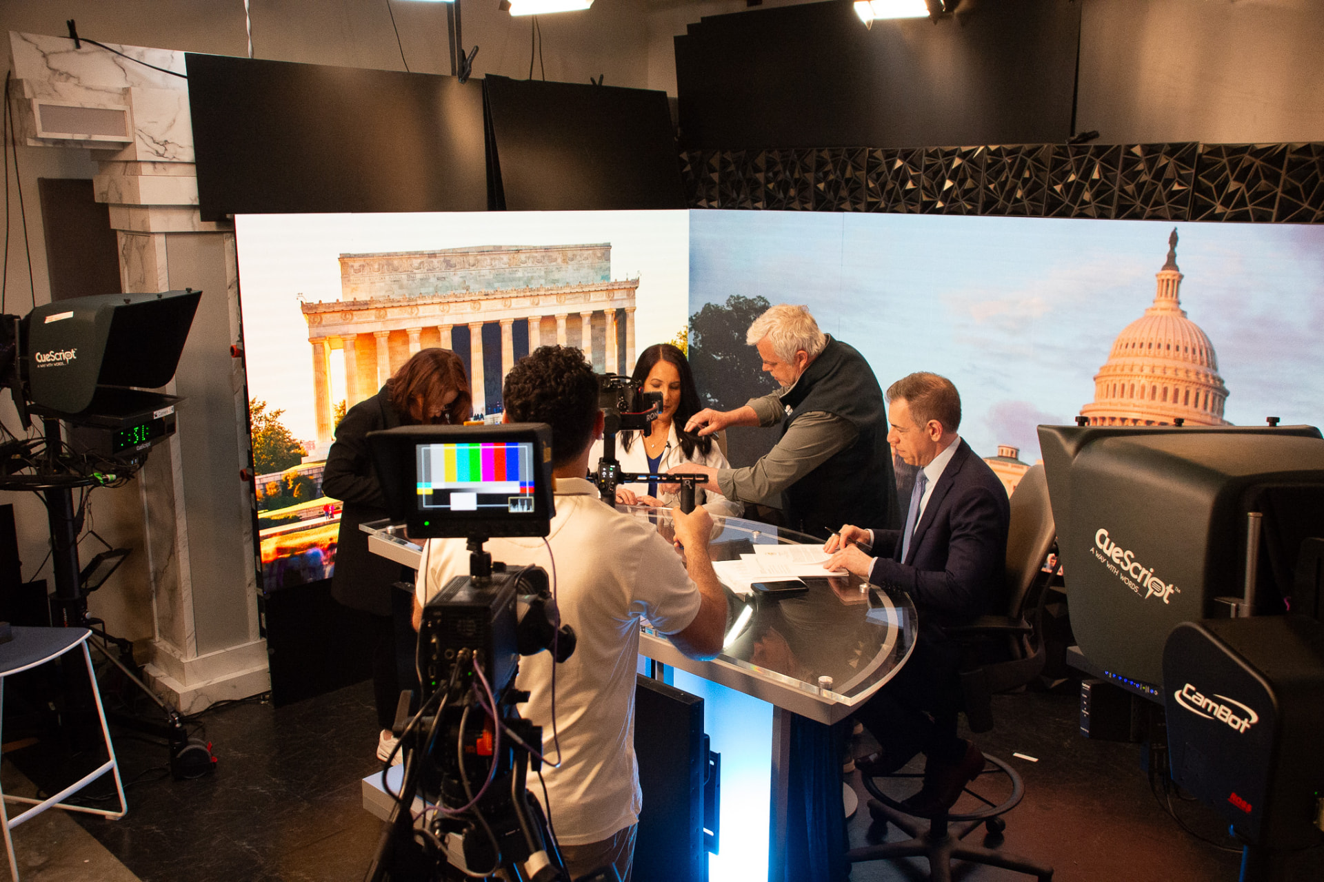 Dr. Marga Macias at the anchor desk during a mock news interview at Media Mastery Experts LIVE!