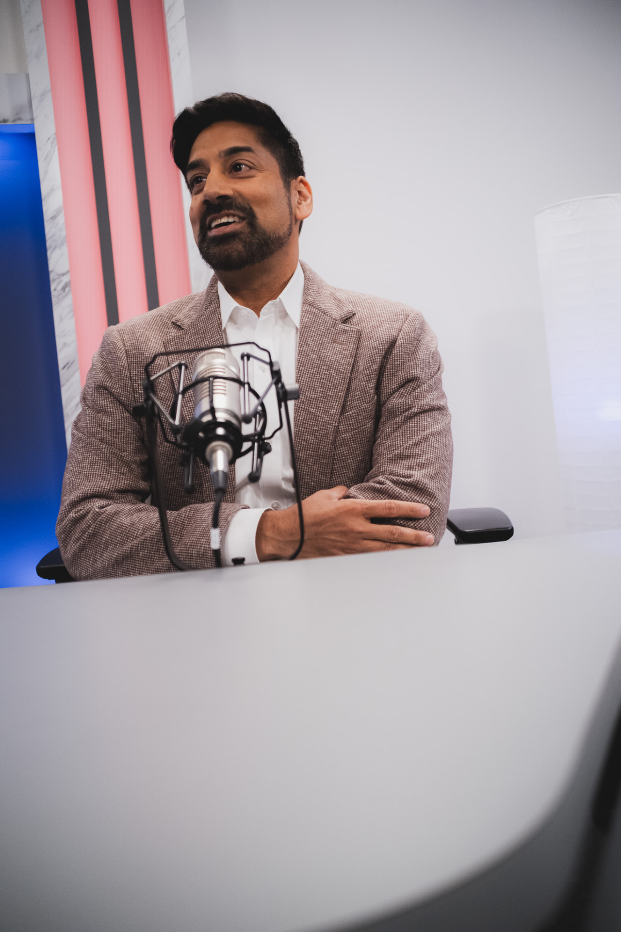 Dr. Amar Rewari being interviewed at a podcast microphone during media training